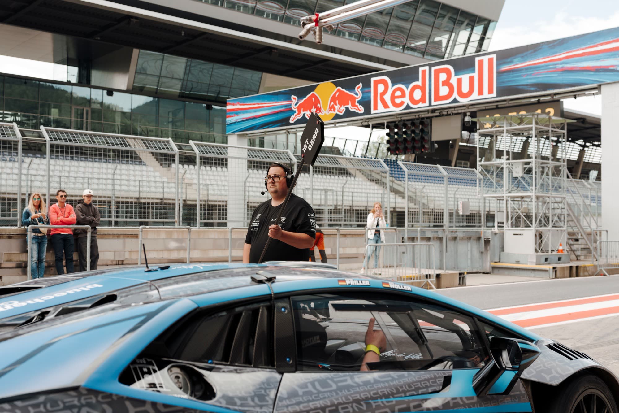Instructor with radio in front of a Lamborghini Huracán in the Red Bull Ring pit lane